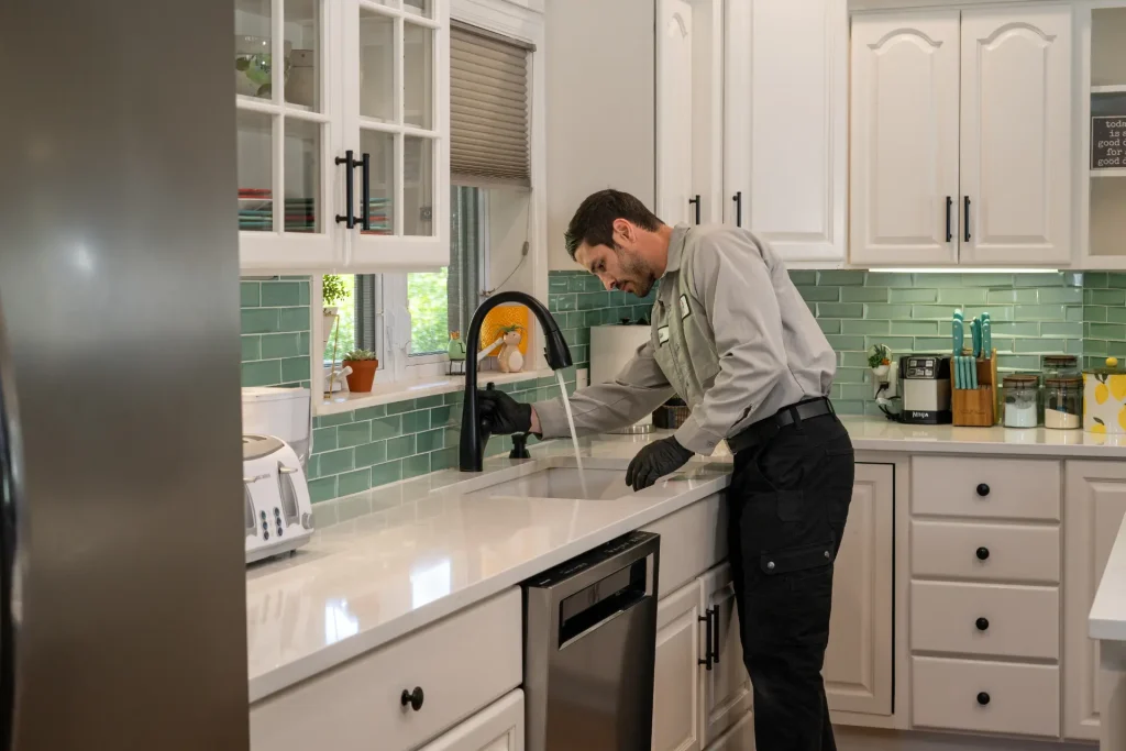 M&M plumber inspecting a kitchen sink and disposal