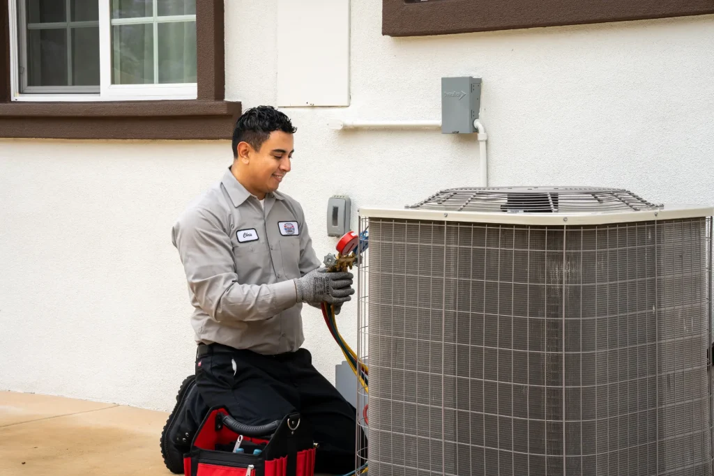M&M technician servicing an outdoor heat pump unit